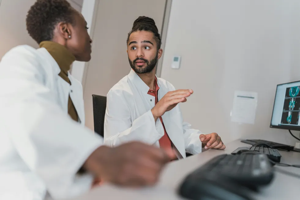 Two medical professionals discussing diagnostic imaging — teamwork and communication in modern healthcare